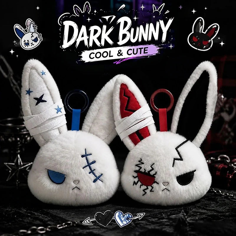 A pair of white bunny plush keychains with distressed features and red accents against a dark background.