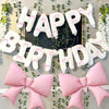 A decorative banner featuring white and pink letters spelling 'Happy Birthday' made from balloons and accented with pink bows