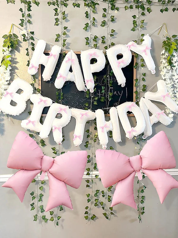 A decorative banner featuring white and pink letters spelling 'Happy Birthday' made from balloons and accented with pink bows