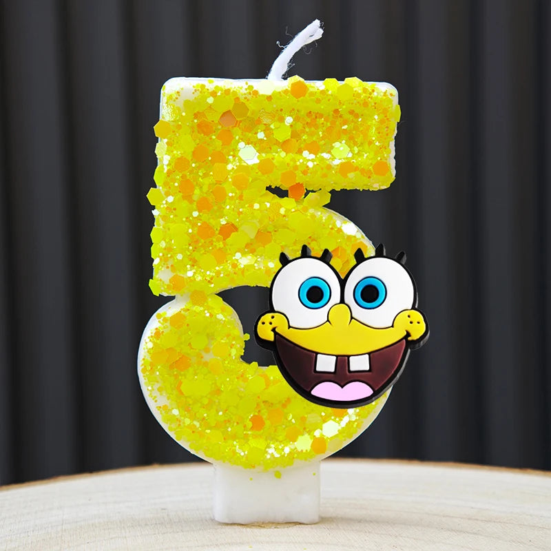 A yellow sponge cake candle shaped like the number 5, featuring a cartoon face.