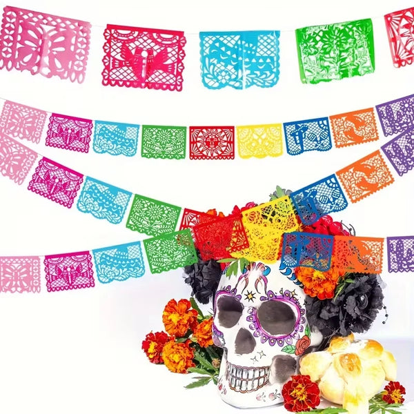 A colorful papel picado bunting banner featuring intricate cut-out designs in pink, blue, green, and orange for Mexican celeb