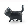 A black 3D cartoon cat figurine used as a refrigerator magnet.