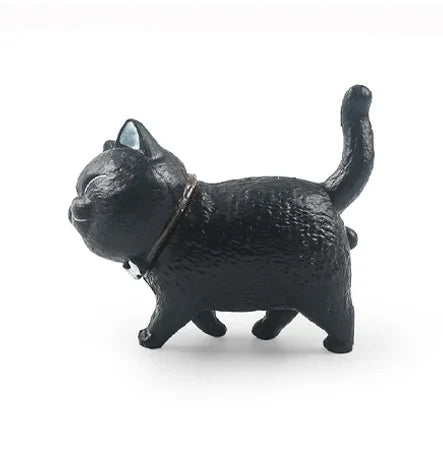 A black 3D cartoon cat figurine used as a refrigerator magnet.