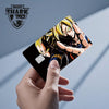 A hand holds a Dragon Ball Super Saiyan card skin sticker featuring Goku in a dynamic pose.