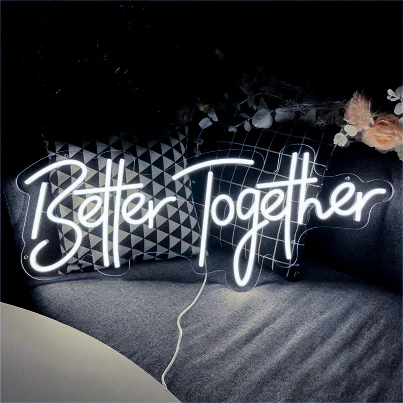 A glowing neon sign spelling out Better Together is displayed on a dark surface.