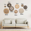 A collection of round boho straw wall hangings with varying sizes and textures displayed on a white wall.