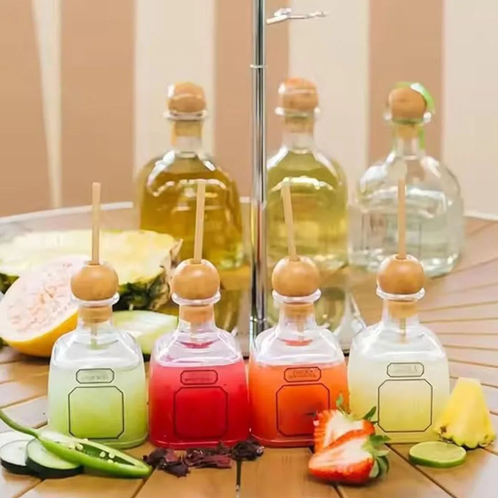 A collection of reusable plastic drinking bottles with straws, some filled with fruit juice and garnished with fresh fruit sl