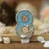 Glitter number cake topper shaped like the number 8 with a starfish design in blue and silver glitter