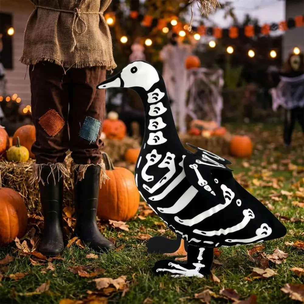 A black and white skeleton goose lawn decor statue standing in an autumn outdoor setting.