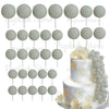A set of white and light gray foam cake toppers on sticks, including round and leaf shapes.