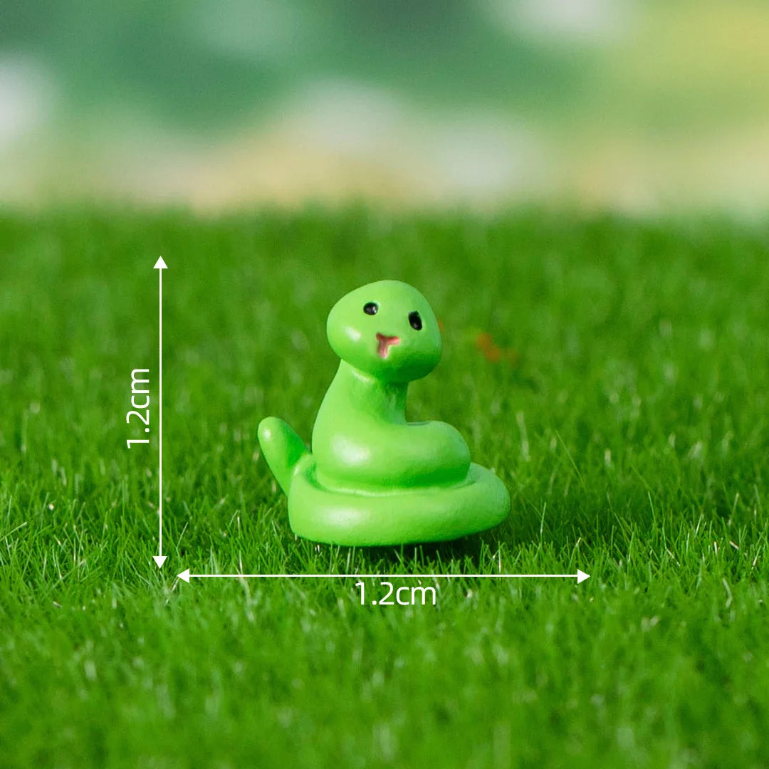 A small, bright green, smooth animal figurine sitting on green grass.