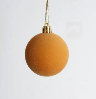A round, golden-toned velvet flocked Christmas tree ornament hanging by a thin gold chain.