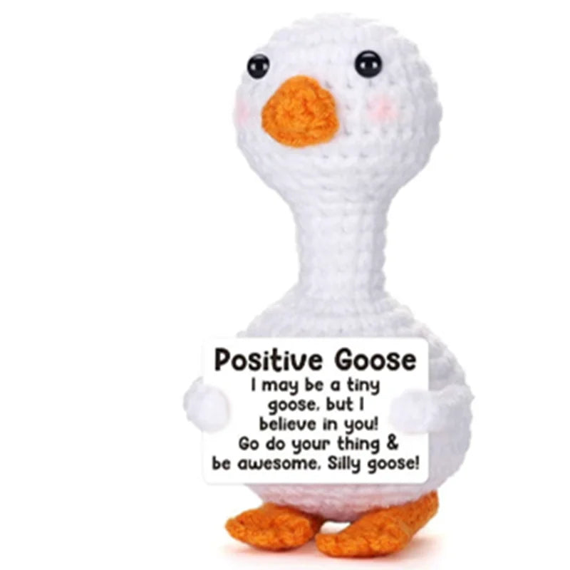 A white plush toy of a goose with an orange beak and feet, labeled Positive Goose.