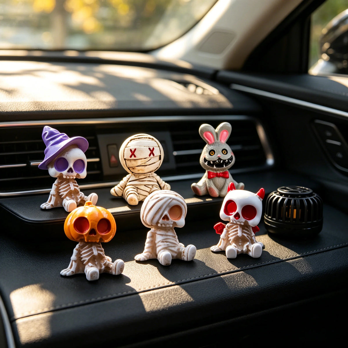 A collection of Halloween resin skeleton mummy figurine toys displayed on a car dashboard.