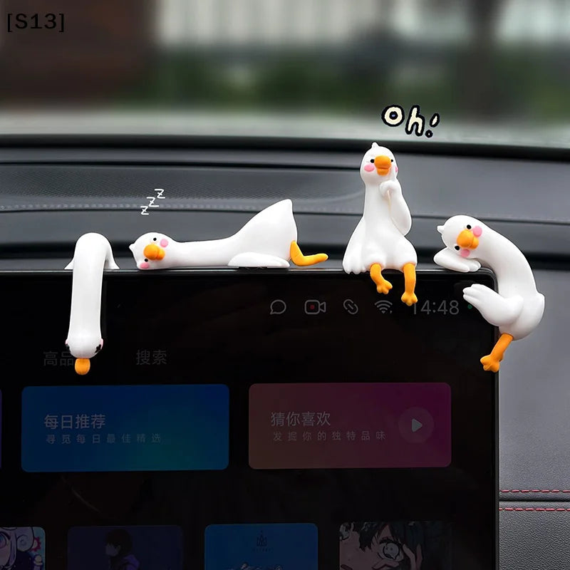 A white resin cartoon duck figurine is displayed on a dark screen, with another duck looking surprised.