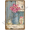 A vintage metal sign featuring a pink tulip bouquet in a blue jug and floral accents.