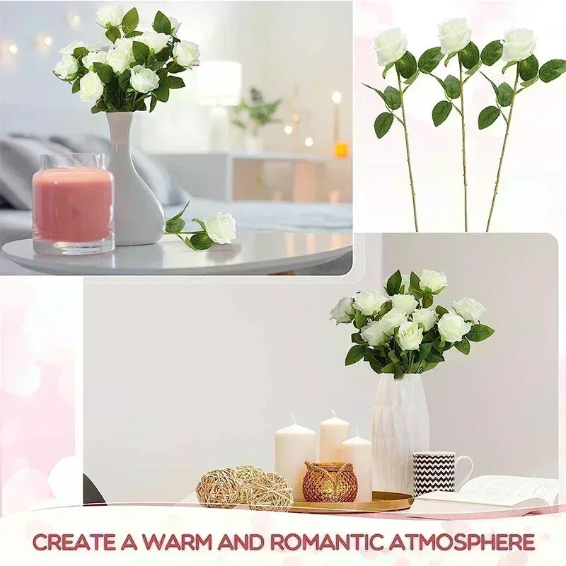 A white artificial silk rose bouquet in a vase displayed next to a glass of pink beverage and candles.