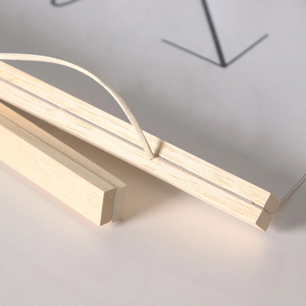 A wooden art frame with a thin wire loop is shown diagonally on a white surface.