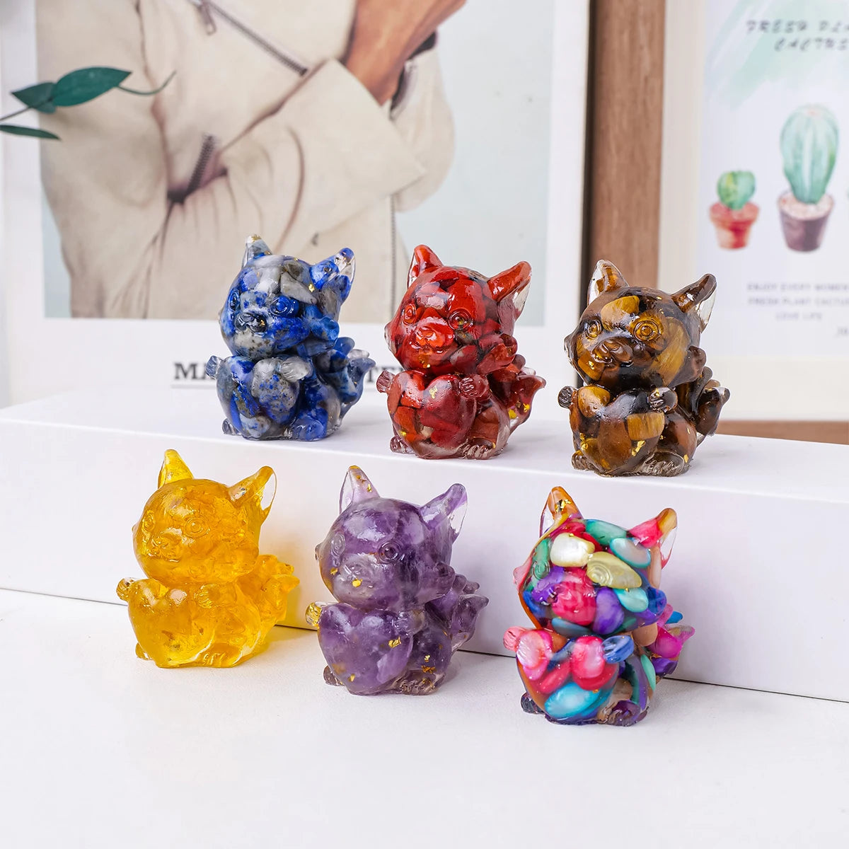 A collection of natural fox crystal sculptures in various colors including blue, red, gold, purple, and pink.