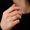 A close-up of a hand wearing a silver signet ring with the Leviathan cross design.