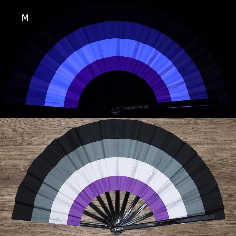 A folding fan with a rainbow color gradient featuring black, gray, white, and purple sections.
