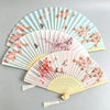 A set of elegant floral bird print bamboo folding fans in pale blue and pink tones.