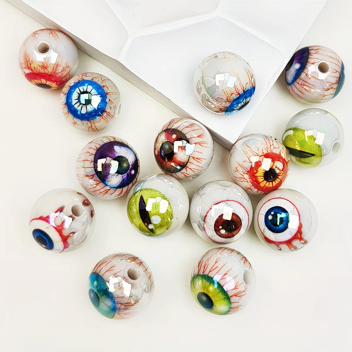 A collection of glossy, double-sided eyeball beads in various colors and patterns for crafting.
