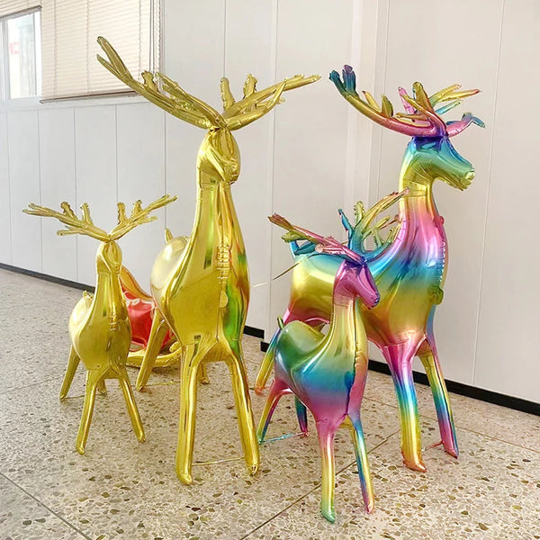 A set of two foil balloons shaped like deer, colored in gold and iridescent rainbow hues.