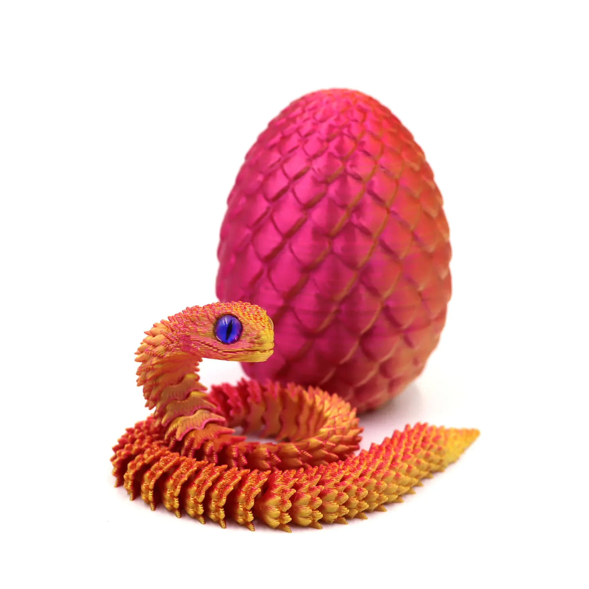 A vibrant orange rainbow snake fidget toy coiled next to a pink egg-shaped object.