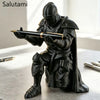 A black 3D printed medieval knight figurine holding a pen, displayed on a light surface.
