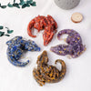 A collection of natural crystal dragon figurines in various colors including red purple blue and gold on a white background.