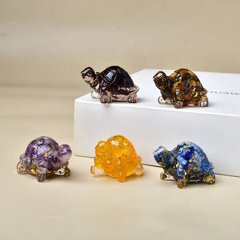 Eine Sammlung von fünf Kristall-Schildkrötenfiguren in verschiedenen Farben darunter dunkelbraun, bernsteinfarben, lila und b