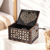 A dark wood music box with an engraved melody is displayed on a white surface.