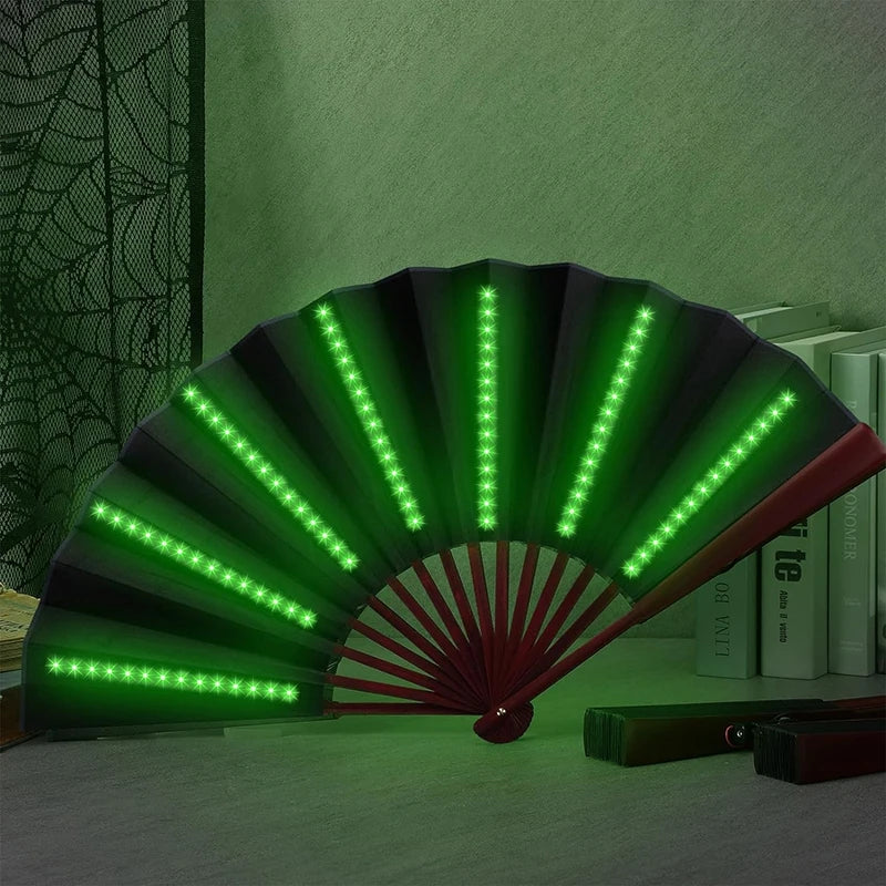 A folding LED fan with green lights is displayed against a green wall.