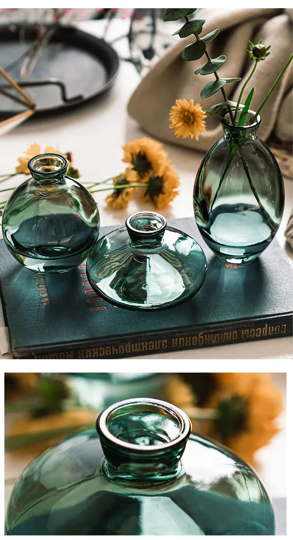 A set of three clear glass mini vases with a teal tint displayed on a dark book.