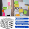 A set of powerful round magnets with a silver finish shown alongside various colored sticky notes and paper in an office sett