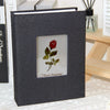 A dark gray linen cover photo album with a square window displaying a red rose and the text Flower language.