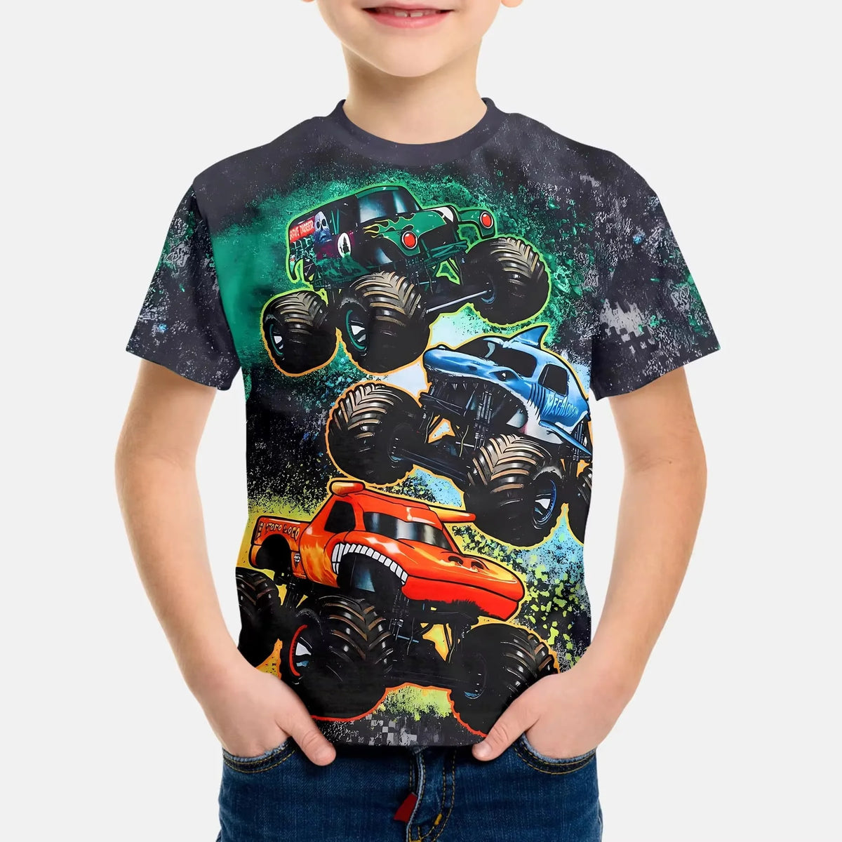 A young boy wearing a black t-shirt featuring a full graphic print of Monster Jam vehicles like Grave Digger and a race car.