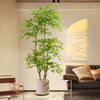 A tall artificial Nandina plant with bright green foliage is displayed indoors against a white wall.