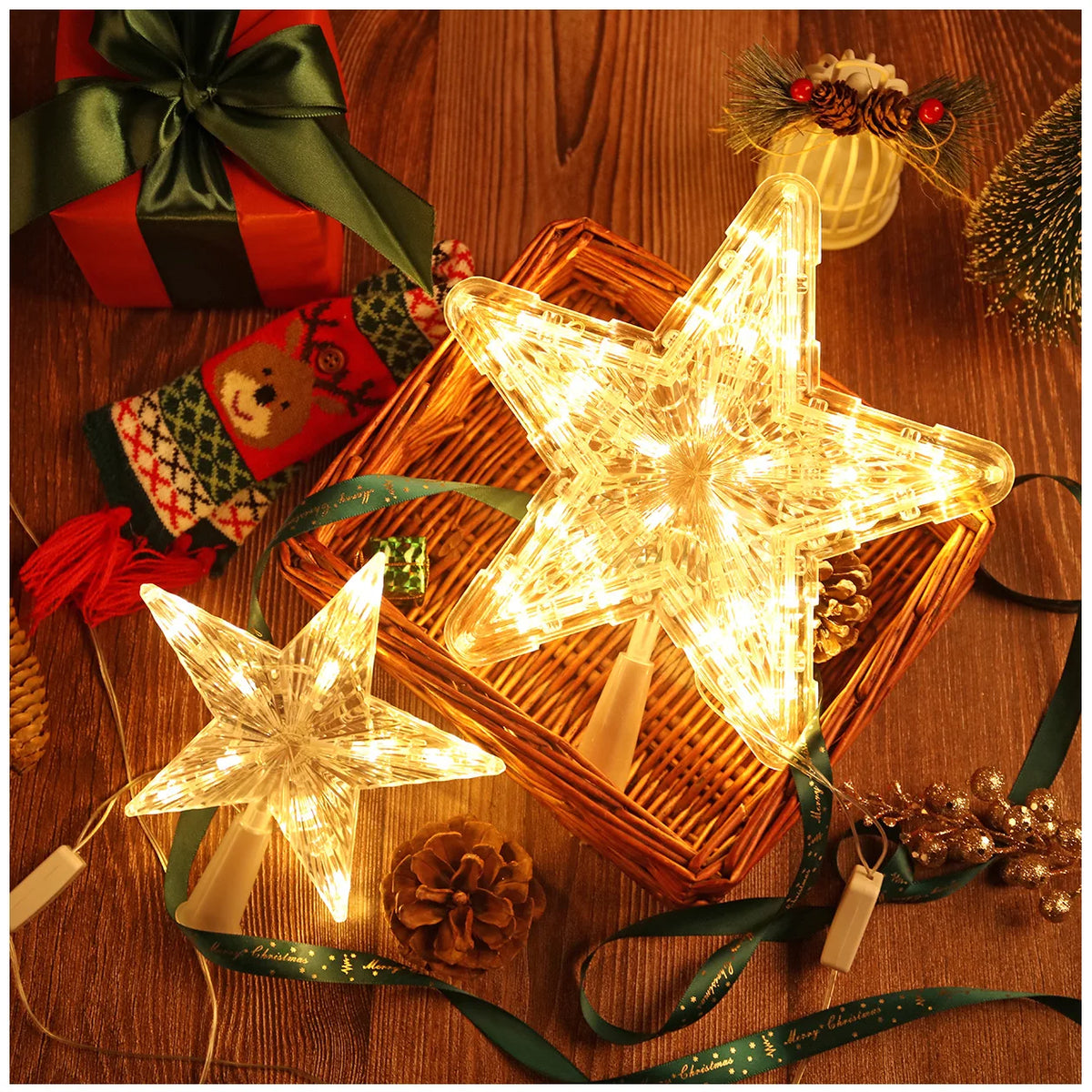 A glowing LED star shaped Christmas tree topper rests in a woven box surrounded by pine cones and green ribbon.