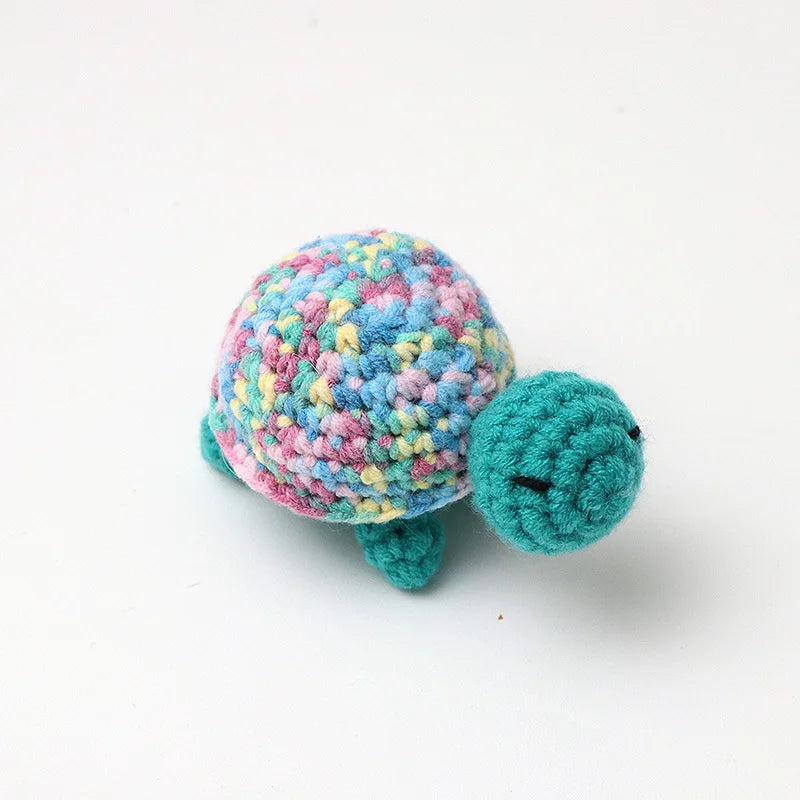 Handmade crocheted turtle plush with multicolored body and green feet