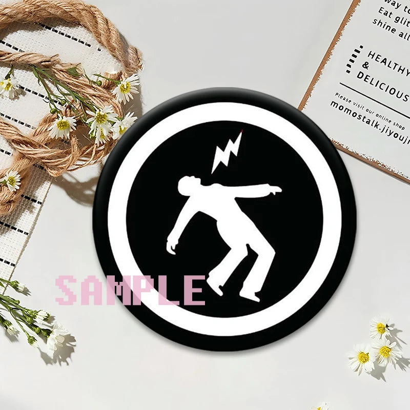 Black button pin featuring a white silhouette of a person with lightning bolts on a circular background