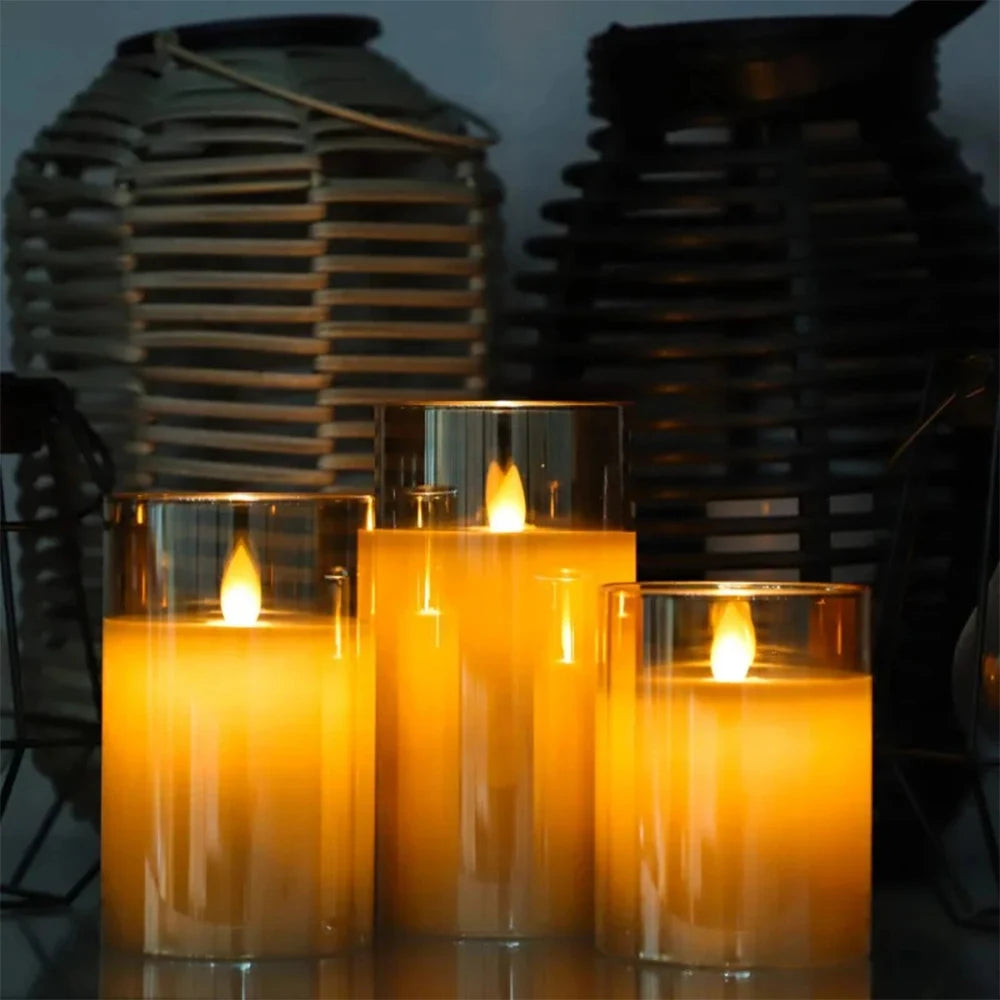 A set of three glass candles with flickering flame effects displayed in a dark setting.