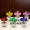 A collection of crystal rose decorative flowers in various colors like yellow, pink, purple, and blue displayed on a white su