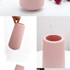 A pink ribbed ceramic flower vase shown in various angles on a white surface.