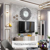 A modern minimalist metal wall clock is displayed on a gray textured wall above a television and furniture.