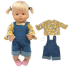 A blonde doll wearing a yellow floral top and denim overalls with pink shoes, accompanied by the outfit pieces.