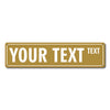 A rectangular brass-colored metal street sign with the text YOUR TEXT and a smaller word TEXT.