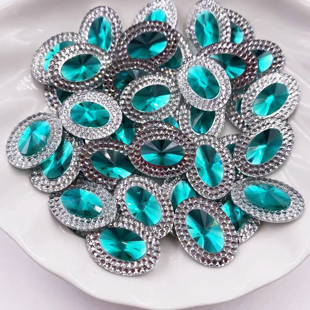 A cluster of turquoise and silver gemstone flatback rhinestones arranged on a white dish.