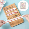 A wooden tray displays various lengths of reusable clear cling film for food storage, showing different measurements.